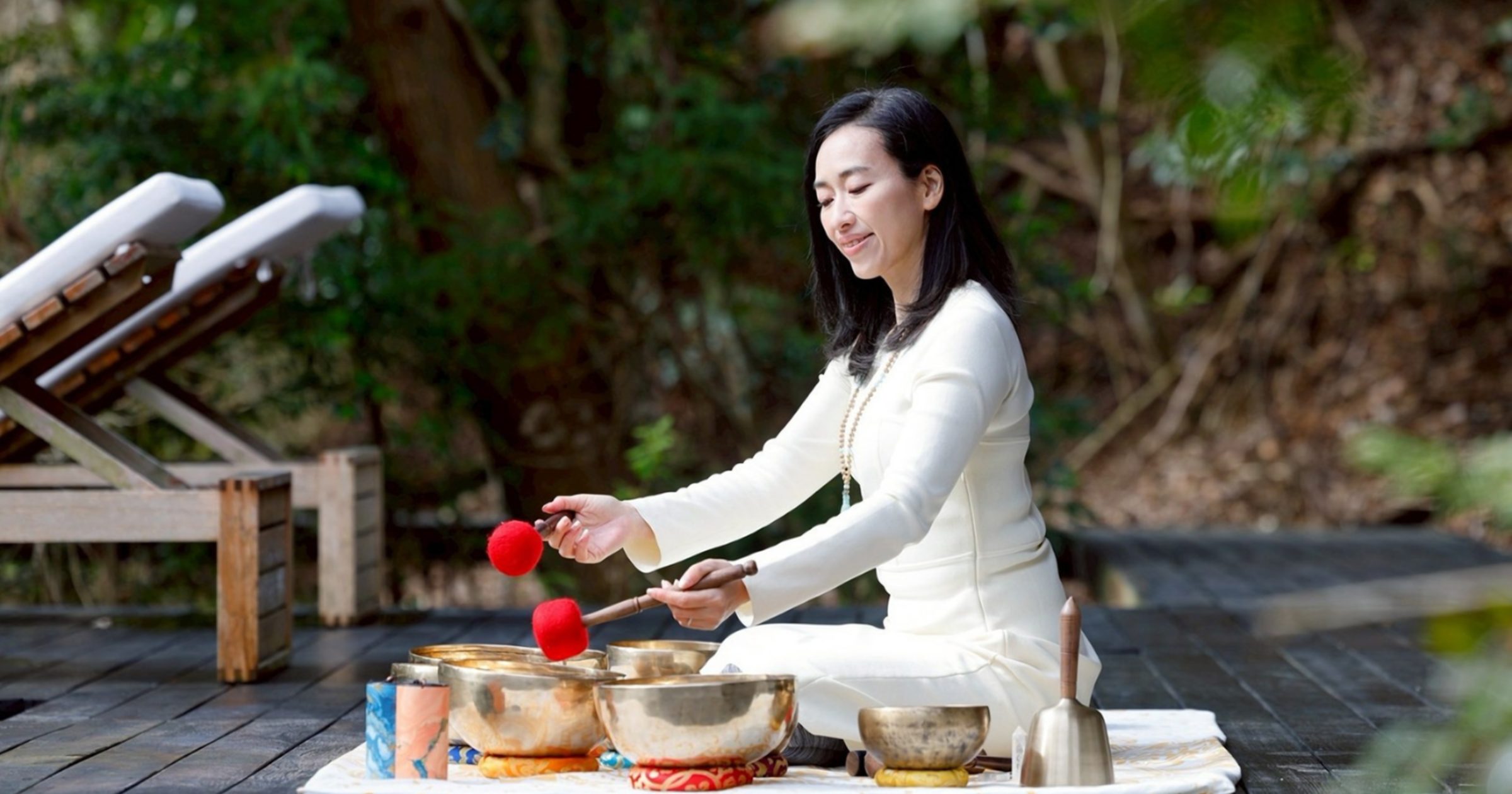 Singing bowl sound bath on an outdoor wooden deck